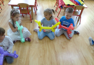 Dzieci trzymają baloniki w kształcie pieska